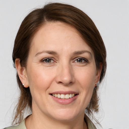 Joyful white adult female with medium  brown hair and grey eyes