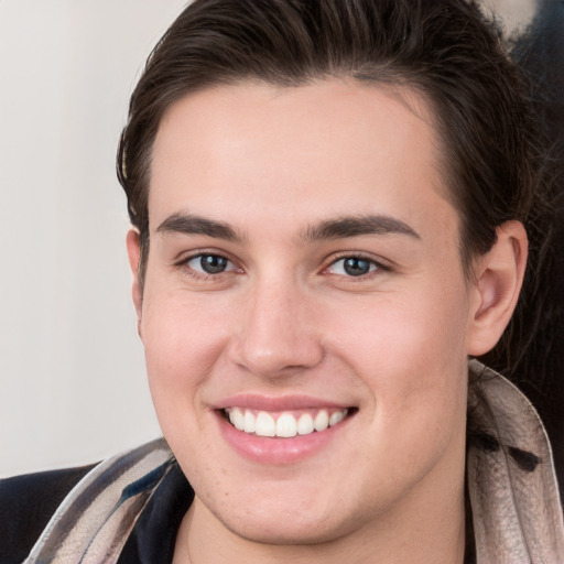 Joyful white young-adult male with long  brown hair and brown eyes