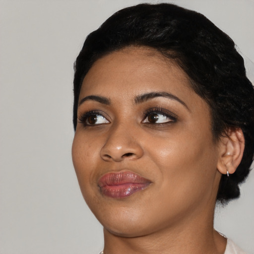 Joyful black young-adult female with short  black hair and brown eyes
