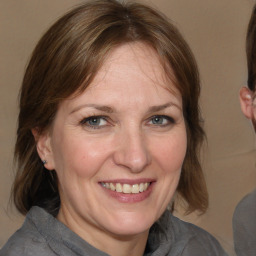 Joyful white adult female with medium  brown hair and grey eyes