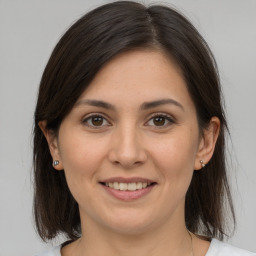 Joyful white young-adult female with medium  brown hair and brown eyes