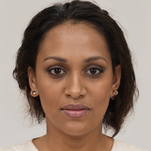 Joyful black young-adult female with medium  brown hair and brown eyes