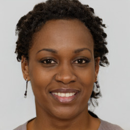 Joyful black young-adult female with short  brown hair and brown eyes