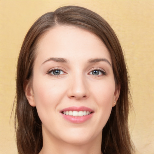 Joyful white young-adult female with long  brown hair and green eyes