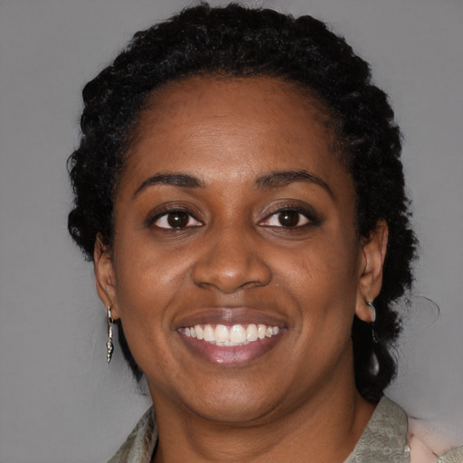 Joyful black adult female with short  black hair and brown eyes