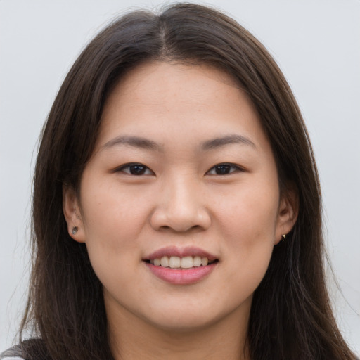 Joyful asian young-adult female with long  brown hair and brown eyes