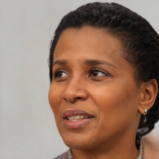 Joyful black adult female with short  black hair and brown eyes