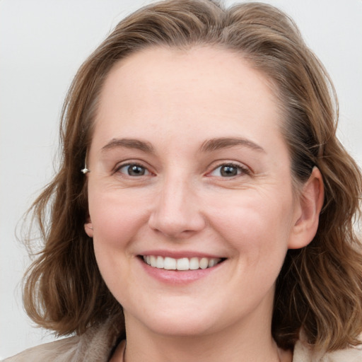 Joyful white young-adult female with medium  brown hair and blue eyes