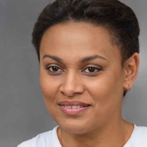 Joyful black young-adult female with short  brown hair and brown eyes