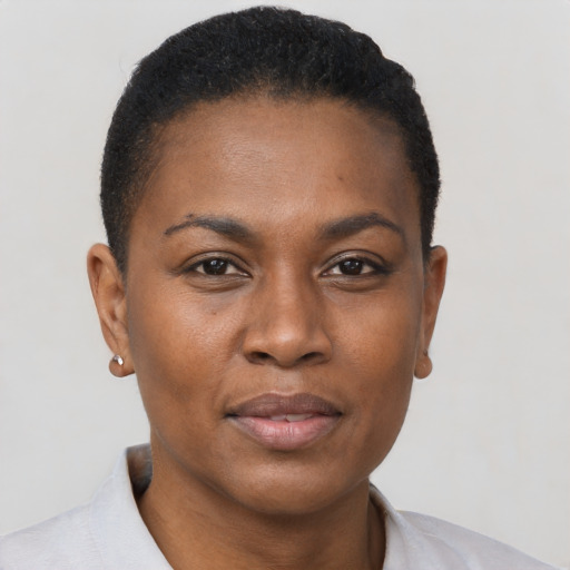 Joyful black young-adult female with short  black hair and brown eyes