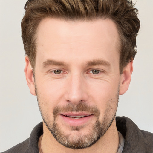 Joyful white adult male with short  brown hair and grey eyes