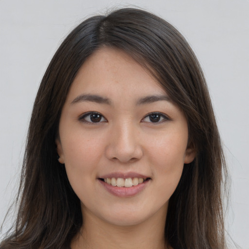 Joyful asian young-adult female with long  brown hair and brown eyes