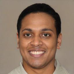 Joyful latino young-adult male with short  black hair and brown eyes