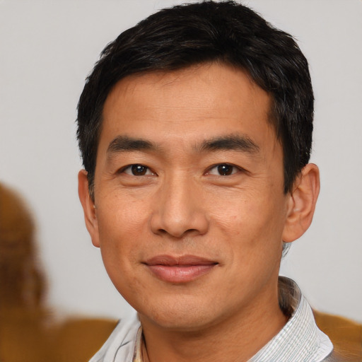 Joyful asian young-adult male with short  brown hair and brown eyes