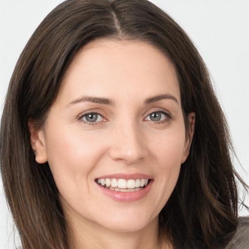 Joyful white young-adult female with long  brown hair and grey eyes