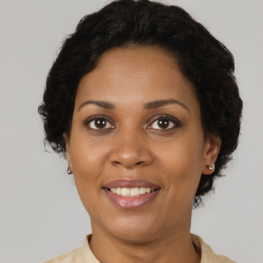 Joyful black adult female with short  brown hair and brown eyes