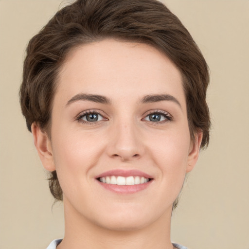 Joyful white young-adult female with short  brown hair and green eyes