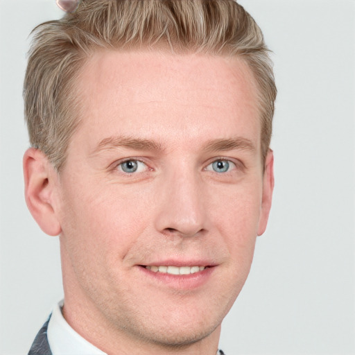 Joyful white young-adult male with short  brown hair and blue eyes