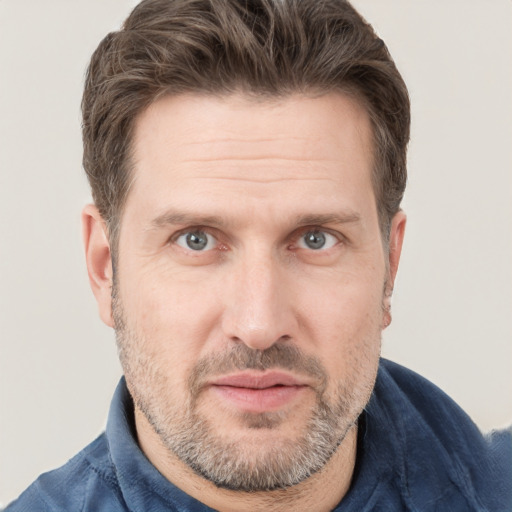 Joyful white adult male with short  brown hair and grey eyes