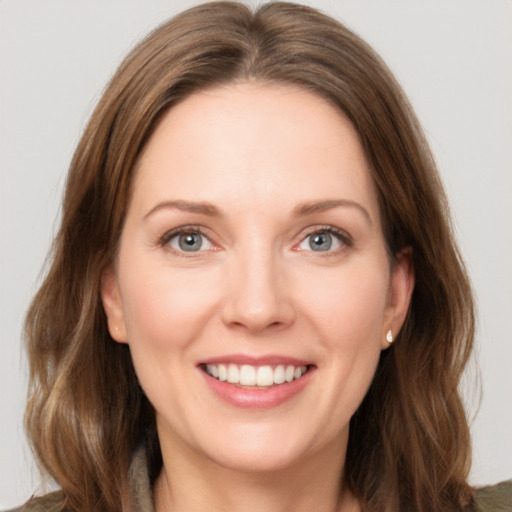 Joyful white young-adult female with long  brown hair and grey eyes