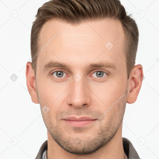 Joyful white young-adult male with short  brown hair and grey eyes