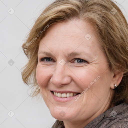 Joyful white adult female with medium  brown hair and blue eyes