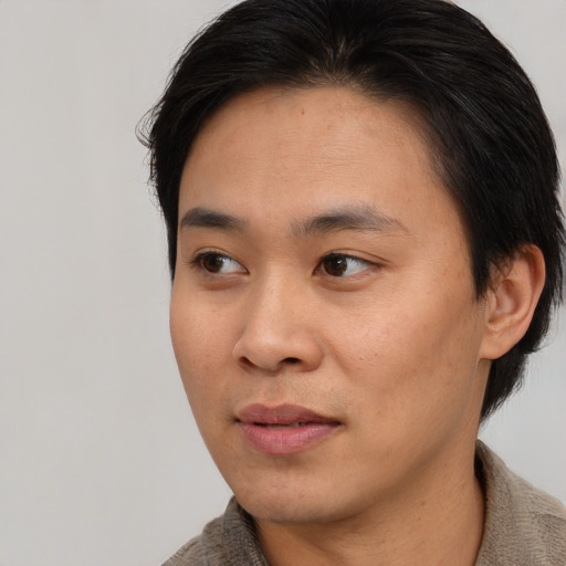 Joyful asian young-adult male with short  brown hair and brown eyes