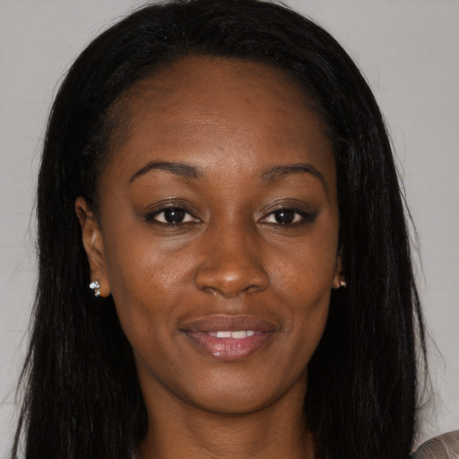 Joyful black young-adult female with long  brown hair and brown eyes