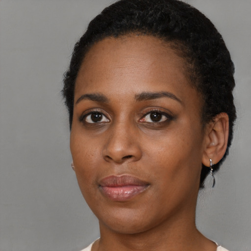 Joyful black young-adult female with short  brown hair and brown eyes