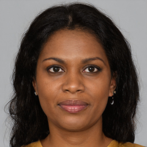 Joyful black young-adult female with long  brown hair and brown eyes