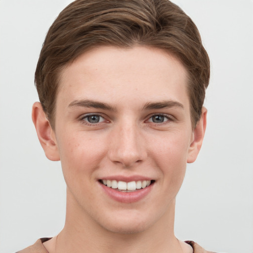 Joyful white young-adult female with short  brown hair and grey eyes