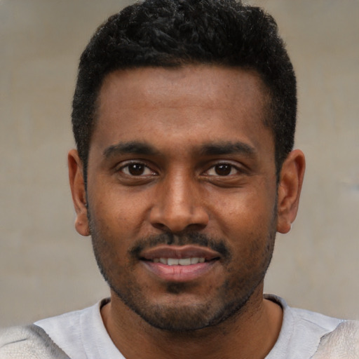 Joyful black young-adult male with short  black hair and brown eyes