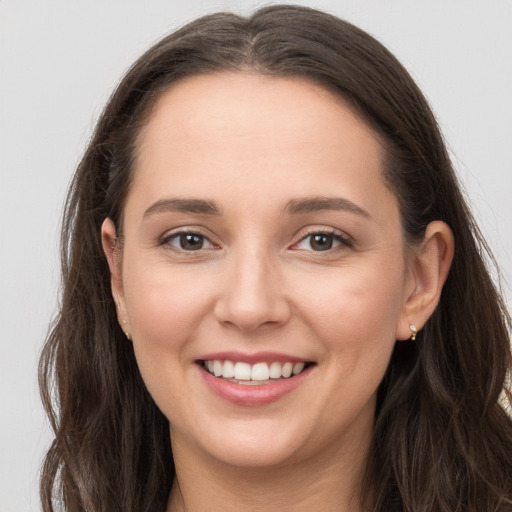 Joyful white young-adult female with long  brown hair and grey eyes