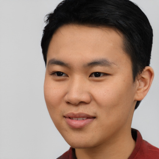 Joyful asian young-adult male with short  black hair and brown eyes