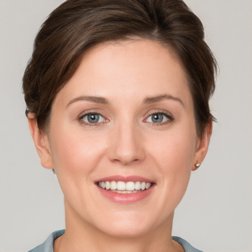 Joyful white young-adult female with short  brown hair and grey eyes