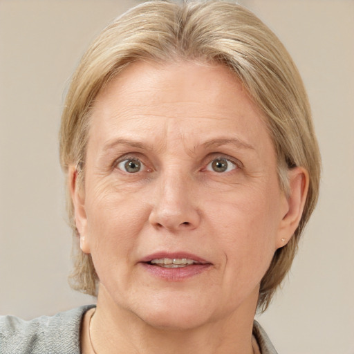 Joyful white middle-aged female with medium  blond hair and grey eyes