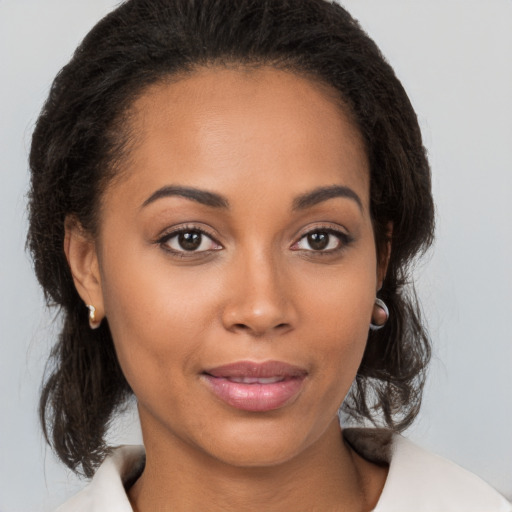 Joyful black young-adult female with medium  brown hair and brown eyes