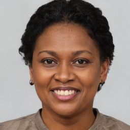 Joyful black adult female with short  brown hair and brown eyes
