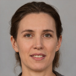 Joyful white adult female with medium  brown hair and grey eyes