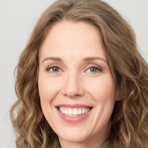 Joyful white young-adult female with long  brown hair and green eyes