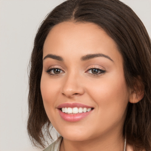 Joyful white young-adult female with long  brown hair and brown eyes