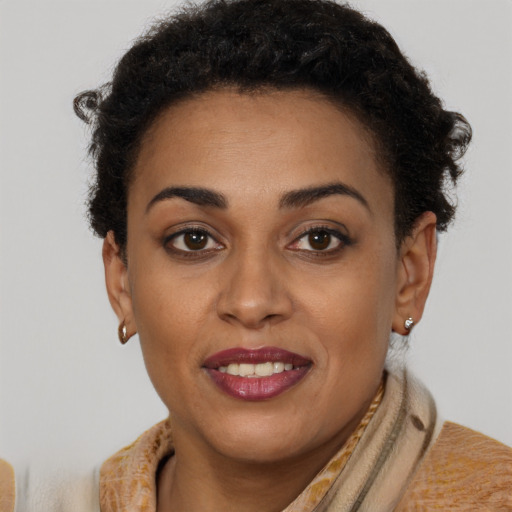 Joyful black young-adult female with short  brown hair and brown eyes