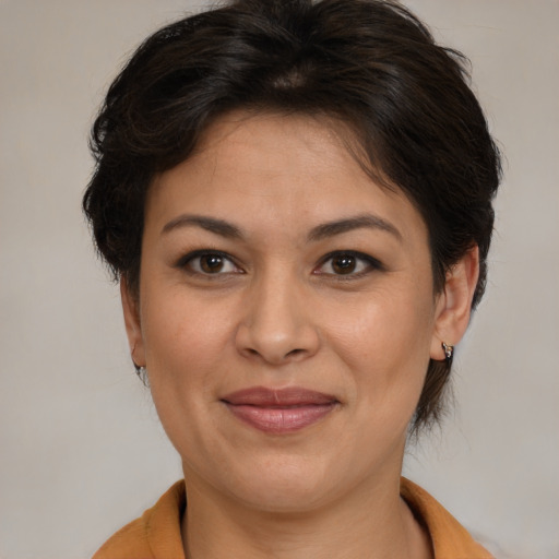 Joyful latino adult female with medium  brown hair and brown eyes