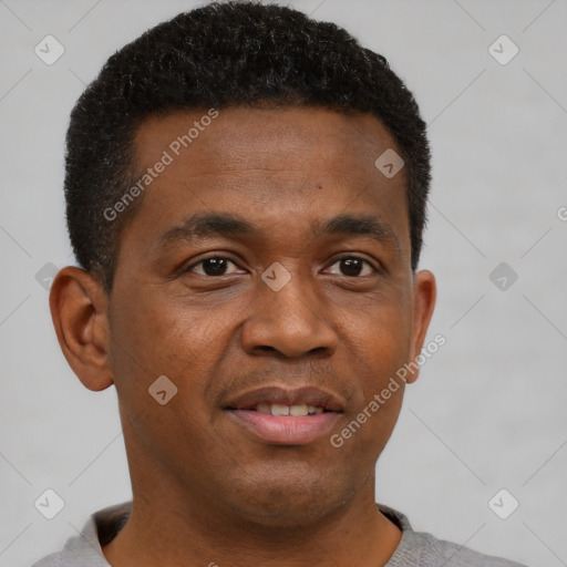 Joyful black young-adult male with short  brown hair and brown eyes