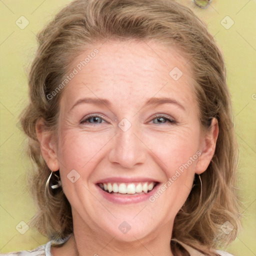 Joyful white adult female with medium  brown hair and blue eyes