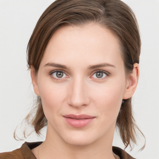 Joyful white young-adult female with medium  brown hair and grey eyes