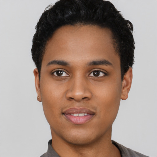 Joyful black young-adult male with short  black hair and brown eyes