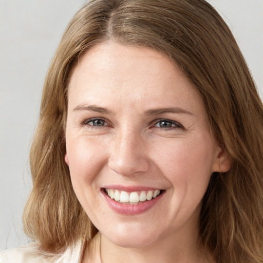 Joyful white young-adult female with long  brown hair and grey eyes