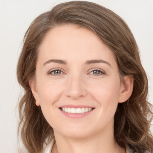 Joyful white young-adult female with medium  brown hair and grey eyes