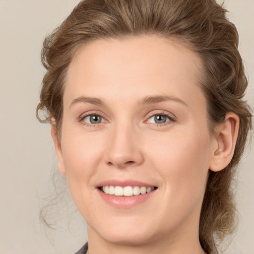 Joyful white young-adult female with medium  brown hair and grey eyes